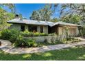 Attractive home with a metal roof, mature landscaping, and a welcoming walkway at 3102 E Trapnell Rd, Plant City, FL 33566