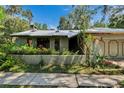 Unique home with architectural details, mature landscaping, and a metal roof at 3102 E Trapnell Rd, Plant City, FL 33566