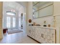 Bright foyer features white plank walls, decorative console, archway, and glass double doors for a grand entrance at 4372 Night Star Trl, Odessa, FL 33556