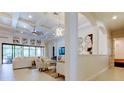Light-filled living room with coffered ceiling, stylish lighting, expansive windows, and elegant decor at 4372 Night Star Trl, Odessa, FL 33556