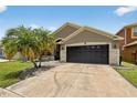 Inviting home features a spacious driveway, a two-car garage, and lush landscaping that enhances its curb appeal at 8620 Sandy Plains Dr, Riverview, FL 33578