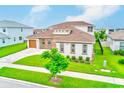 Aerial view of a well-maintained single-Gathering home, featuring a lush green lawn and neutral color palette at 8717 Sanders Tree Loop, Wesley Chapel, FL 33545