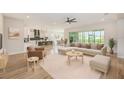 Bright living space with an open floor plan, light wood floors, neutral furniture and contemporary finishes at 8717 Sanders Tree Loop, Wesley Chapel, FL 33545