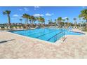 Resort-style community pool with palm trees and lounge chairs for relaxation at 9650 Sage Creek Dr, Ruskin, FL 33573