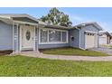 Inviting home exterior showcasing a well-kept lawn, quaint front door, and a one-car garage at 11451 82Nd Ave, Seminole, FL 33772