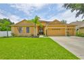 Charming home boasts lush lawn, mature trees, and a spacious three car garage at 12305 Freesia Ct, Riverview, FL 33569