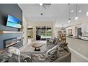 Cozy living room with a modern fireplace, stylish furniture, and open access to the kitchen and pool area at 2226 Charleston Park Dr, North Port, FL 34287