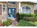 Inviting entryway with a bright blue front door, brick walkway, and manicured landscaping at 23346 Abercorn Ln, Land O Lakes, FL 34639