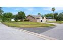 Well-maintained home exterior with a two-car garage, manicured lawn, and a serene corner lot at 2421 Eagle Chase Dr, Palm Harbor, FL 34683