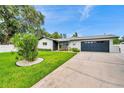 Attractive single-story home with a green lawn, a two-car garage and fresh landscaping at 3436 Manatee Se Dr, St Petersburg, FL 33705