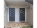 Close-up of unit doors with brick walkway and sconce lighting at 5125 Puritan Cir # 1103, Tampa, FL 33617