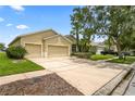 Single-story home featuring a lush landscaped yard, mature trees, a two-car garage and a long driveway at 11810 Holly Creek Dr, Riverview, FL 33569