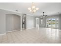 Open living room with tile floors, neutral walls and ceiling fan. French doors open to the lanai at 11810 Holly Creek Dr, Riverview, FL 33569