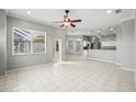 Open living room with tile floors, neutral walls and ceiling fan. View into the kitchen at 11810 Holly Creek Dr, Riverview, FL 33569