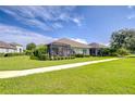 Private backyard featuring a screened lanai, manicured lawn, and lush landscaping for serene outdoor living at 13621 Circa Crossing Dr, Lithia, FL 33547