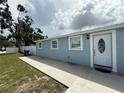 Charming single-story home with a white door, light blue exterior and a well-kept lawn at 2927 W Henry Ave, Tampa, FL 33614
