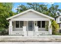 Charming single-story home featuring a fenced yard, symmetrical columns, and a cozy front porch at 3105 N 16Th St, Tampa, FL 33605