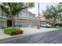 Inviting townhome exterior with multi-car garage and lush, landscaped front yard at 3298 Covered Bridge W Dr, Dunedin, FL 34698