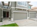 Townhome exterior showcasing a multi-car garage and a covered front entryway at 3298 Covered Bridge W Dr, Dunedin, FL 34698