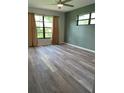 Comfortable bedroom featuring gray wood flooring and view of backyard at 3610 54Th W St # B8, Bradenton, FL 34209