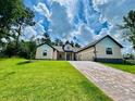 Beautiful single-story home featuring a spacious paved driveway and a lush green lawn at 4800 Hickory Oak Dr, Brooksville, FL 34601