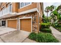 Townhome garages featuring stone accents and beautifully landscaped surroundings at 7001 Interbay Blvd # 121, Tampa, FL 33616