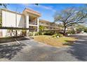 Wide exterior shot of the condo buildings and carports on a sunny day at 840 Virginia St # 301, Dunedin, FL 34698