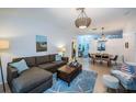 Comfortable living room with a sectional sofa, a wooden coffee table, a blue rug, and a view into the dining area at 878 Franklin Cir, Palm Harbor, FL 34683