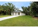 Well-manicured lawn and landscaping surround this charming single-story home at 18146 Sinatra Ave, Port Charlotte, FL 33954