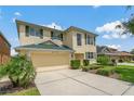 This home features a beautiful lawn, two car garage, and yellow stucco exterior with green shutters at 20115 Nob Oak Ave, Tampa, FL 33647