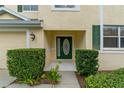 The front of this home features an eye-catching green door and neatly manicured shrubbery around the home at 20115 Nob Oak Ave, Tampa, FL 33647