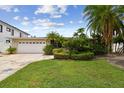 Well-maintained home featuring lush landscaping, a green lawn, and a two-car garage at 3921 E Eden Roc Cir, Tampa, FL 33634