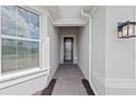 Inviting entryway with a dark front door, stone pathway, and sidelight window at 6982 Minneola Ct, Nokomis, FL 34275