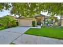 Charming single-story home featuring an attached two-car garage and well-manicured front lawn at 12218 Avondale Oak Pl, Riverview, FL 33578