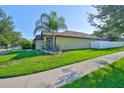 View of a well-maintained home with a lush green lawn and a pristine white fence at 12218 Avondale Oak Pl, Riverview, FL 33578
