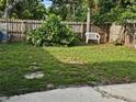 Grassy backyard features a white bench and lush greenery, offering a serene and private outdoor space at 1596 S Evergreen Ave, Clearwater, FL 33756