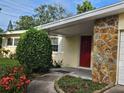 Inviting front entrance with stone accents, covered porch, and a vibrant red door for a pop of color at 1596 S Evergreen Ave, Clearwater, FL 33756