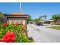 Entrance to Tahitian Place featuring lush hibiscus and glimpses of covered parking at 1980 Tahitian Pl # 10, Dunedin, FL 34698