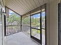 Screened porch view showing exterior landscape and the entrance to another unit at 3964 Dream Oak Pl # 203, Tampa, FL 33613