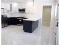 Modern kitchen with stainless steel appliances, two-tone cabinets, and marble floors at 4720 Murray Hill Dr, Tampa, FL 33615