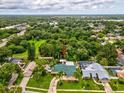 A panoramic aerial view showcases this home's placement in a lush, wooded area with easy access to nearby waterways at 5110 Lake Valencia E Blvd, Palm Harbor, FL 34684