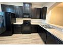 Modern kitchen featuring sleek black appliances and laminate countertops at 8819 Walnut Gable Ct, Riverview, FL 33578