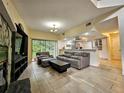 Open-concept living room with stone fireplace, tile flooring, and views of the kitchen at 10928 Echo Loop, New Port Richey, FL 34654