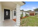 Close up of front entryway with decorative stone column and black front door with window at 4410 Lurline Cir, Tampa, FL 33610