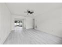 Bright and airy living room with light grey flooring, ceiling fan, and glass sliding doors at 4410 Lurline Cir, Tampa, FL 33610