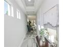 Light-filled hallway with modern flooring and artwork at 7780 Hidden Creek Loop # 101, Lakewood Ranch, FL 34202