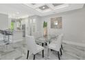Modern dining room features a glass table and light gray chairs at 7730 Hidden Creek Loop # 101, Lakewood Ranch, FL 34202