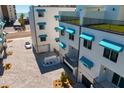 Modern condo exterior with stylish awnings and a paved courtyard entrance to the garage at 15405 Gulf Blvd # B1, Madeira Beach, FL 33708