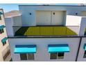 The private rooftop terrace features artifical turf and a secure black metal railing at 15405 Gulf Blvd # B1, Madeira Beach, FL 33708