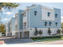 Three-story building with light blue siding, white accents, and landscaping at 1413 Bayshore Blvd # 13, Dunedin, FL 34698